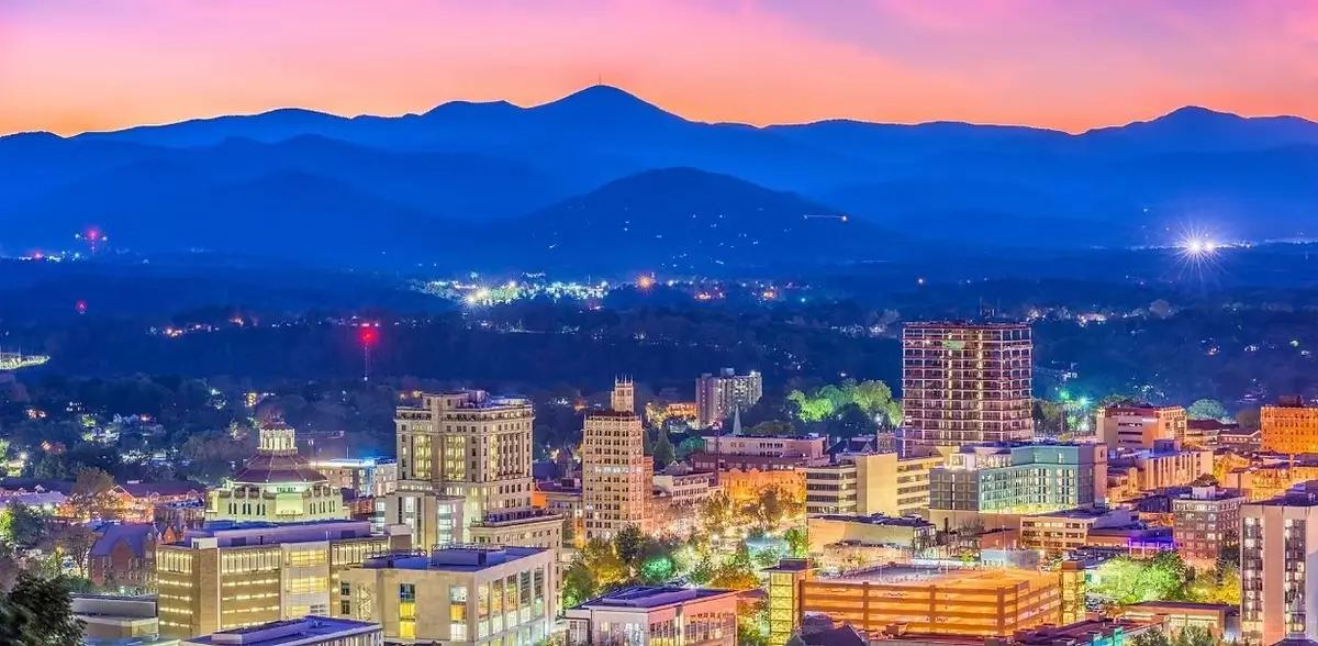 Asheville city skyline at sunset with Blue Ridge Mountains in the background