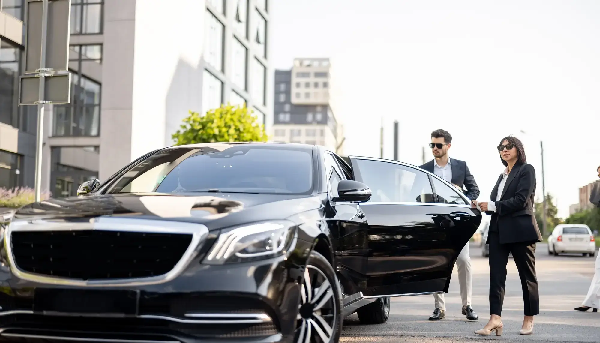 Chauffeur opening luxury black car door for prom transportation in Charlotte NC