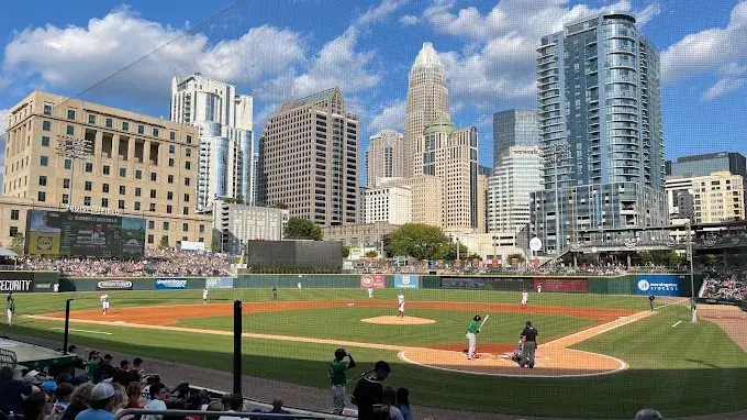 Baseball game at Truist Field with Charlotte skyline in the background and players on the field