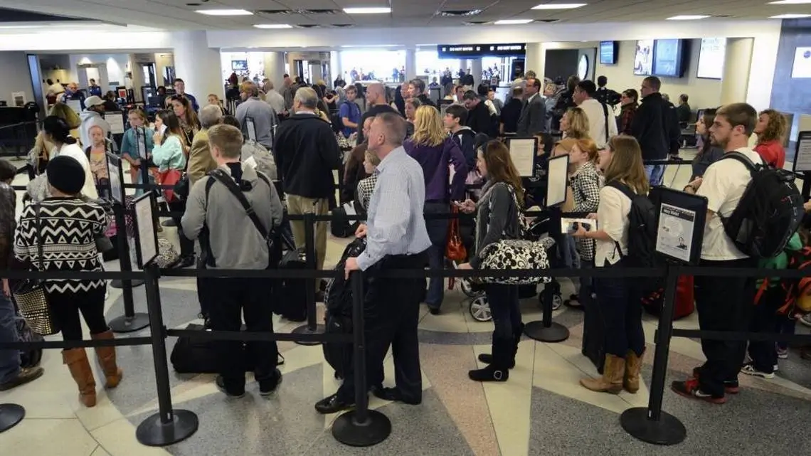 Crowded airport security line during peak summer travel with VOY Black Car airport service