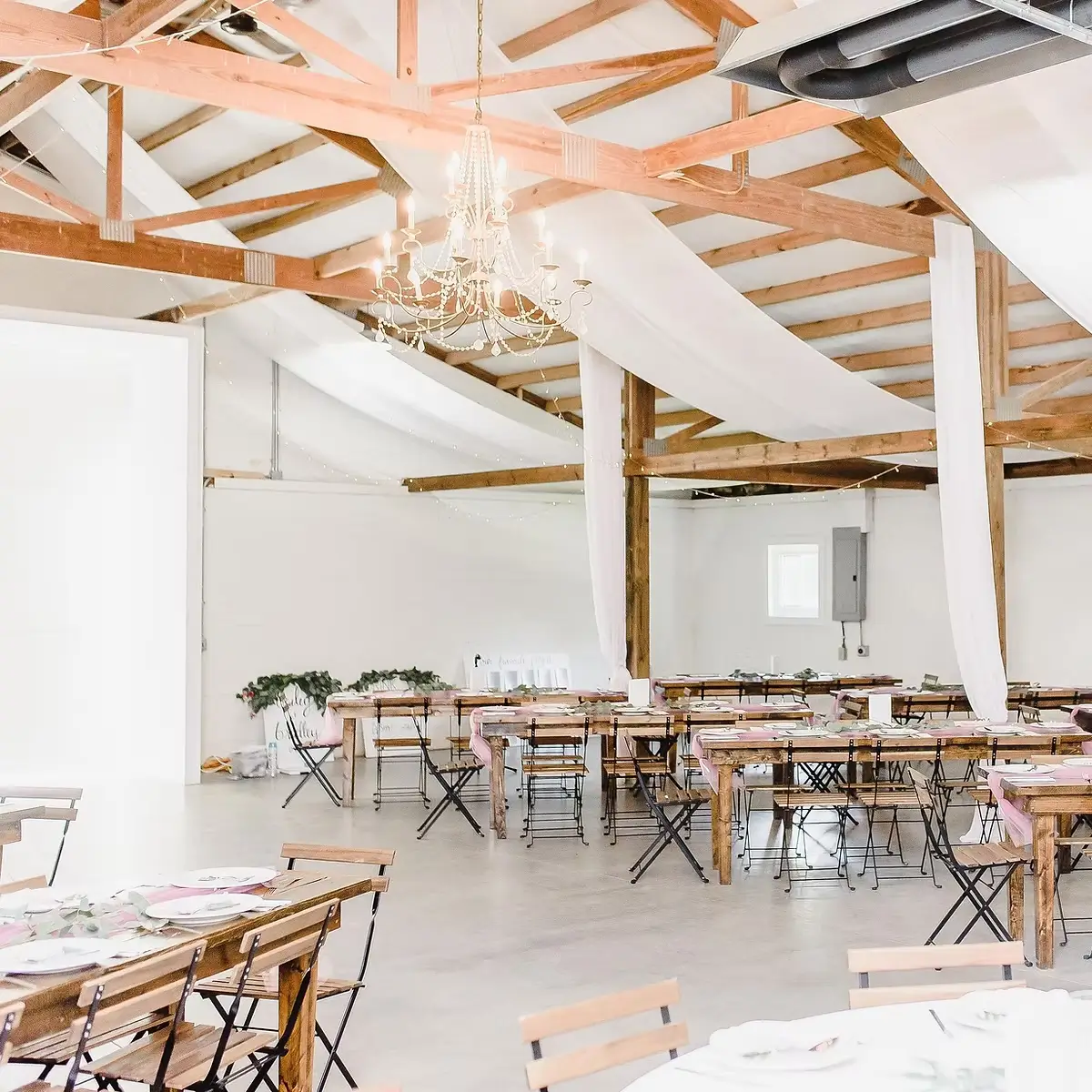 Indoor wedding setup at The Ruth venue with tables, chairs, and chandelier lighting in Charlotte