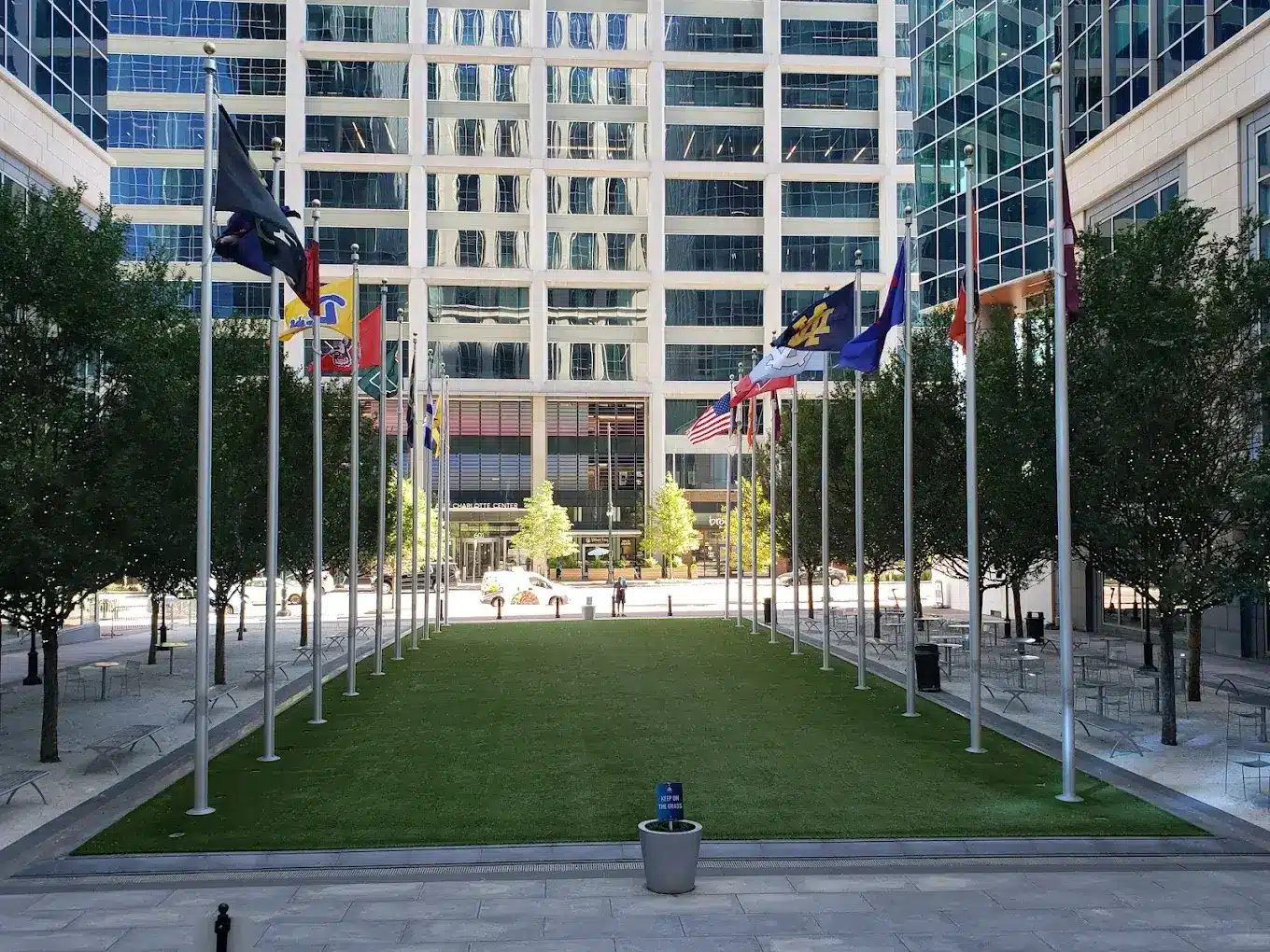 Uptown Charlotte plaza lined with international flags, highlighting the relocation of ACC headquarters to the city