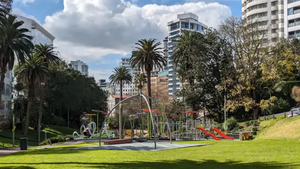 Family-friendly playground and green park space in Myers Park Charlotte with skyline in background
