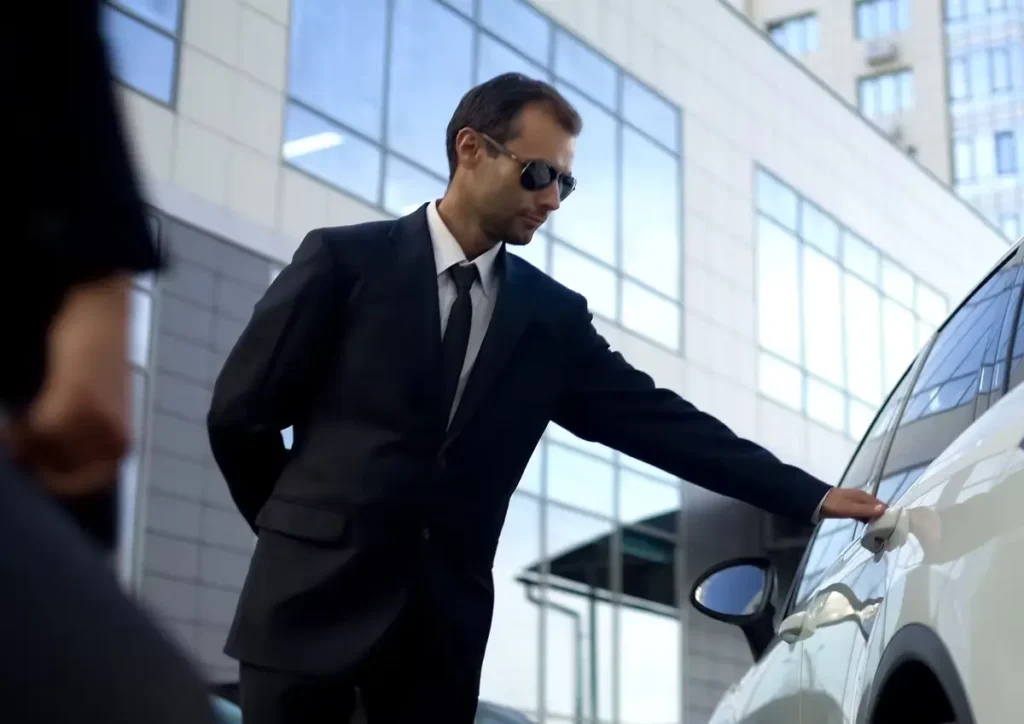 Professional chauffeur opening car door for client in luxury vehicle