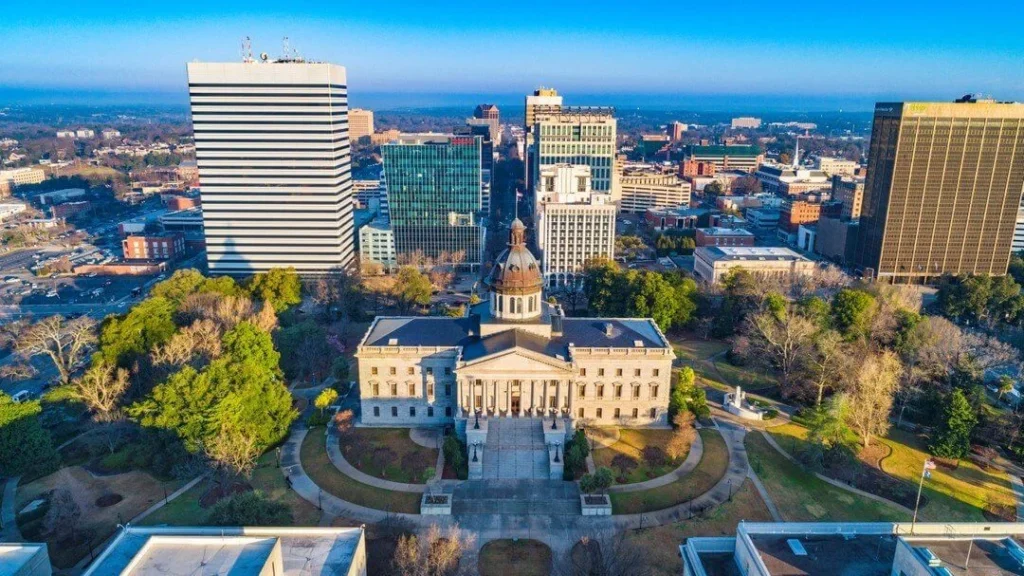 Aerial view of Columbia's State House surrounded by tall buildings and trees.