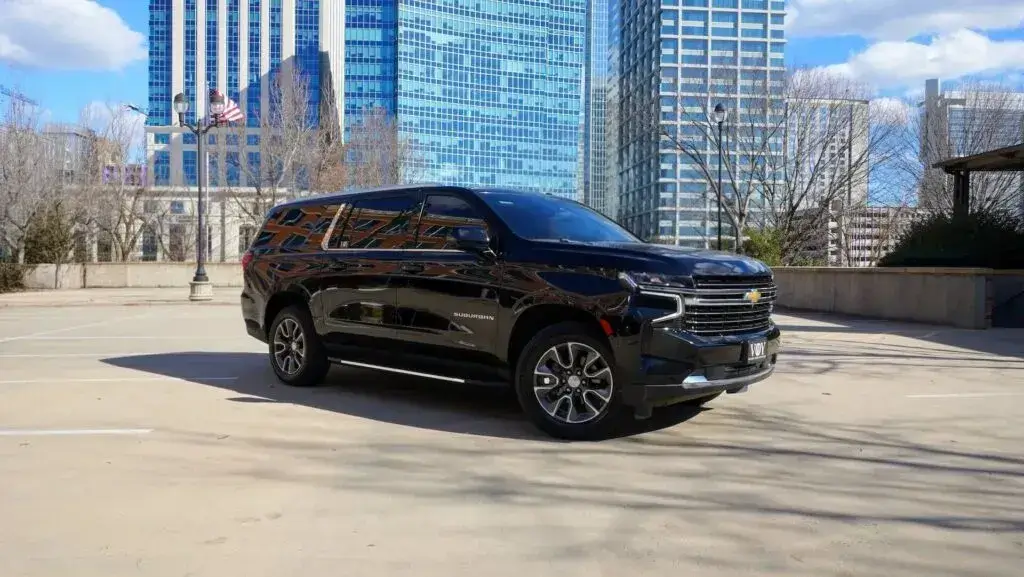 Luxury black SUV executive car service in downtown Charlotte with city skyline backdrop