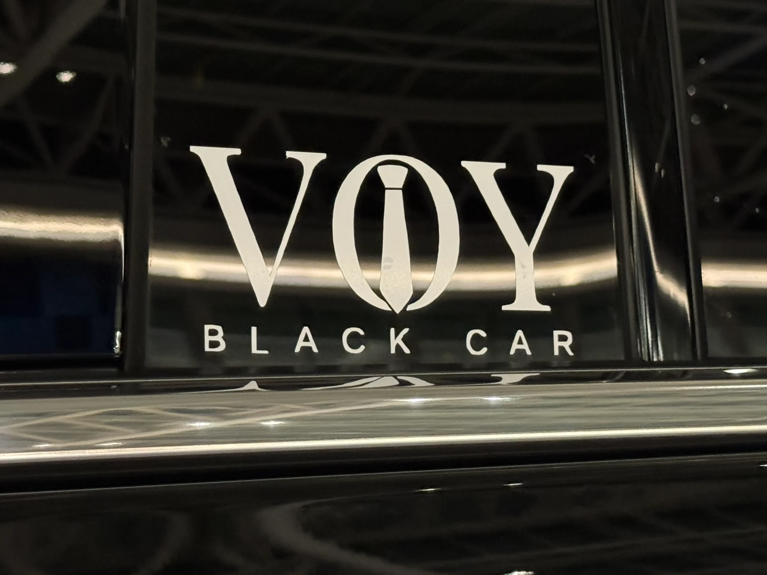 VOY Black Car logo on a black luxury vehicle - the new brand of the former Black Tie Car Service of Charlotte